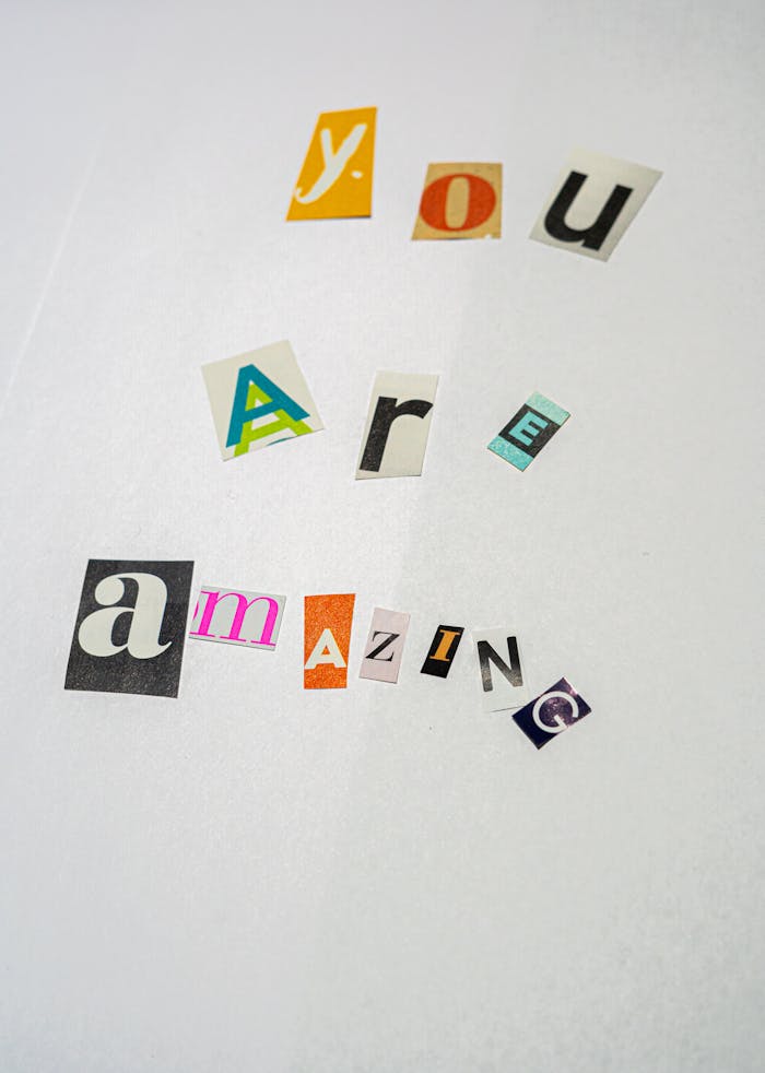 Creative cutout letters forming You Are Amazing on white paper, offering motivation.