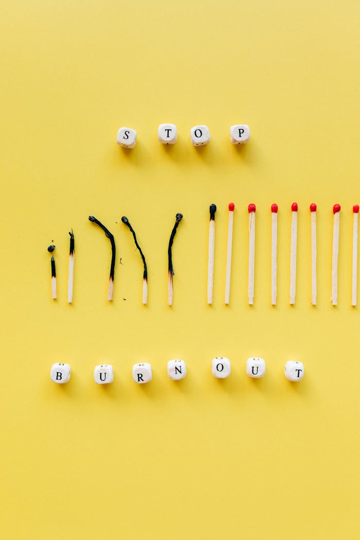 A conceptual photo depicting burnout with matches and dice on a yellow background.